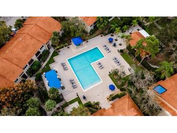 Aerial view of a community pool with lounge chairs and umbrellas at 4053 Crockers Lake Blvd # 2418, Sarasota, FL 34238