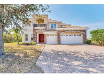 Elegant two-story home with a three-car garage, stone accents, and a manicured front yard at 4307 70Th E Ave, Ellenton, FL 34222