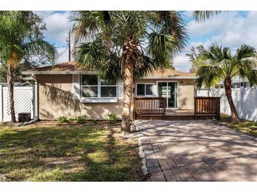 Charming bungalow with a brick driveway, a cozy deck, and lush tropical landscaping at 445 88Th N Ave, St Petersburg, FL 33702