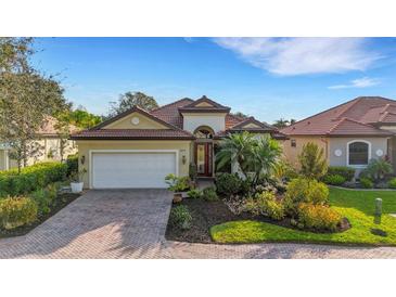 Inviting home exterior with manicured landscaping, a tile roof, and a striking front door at 8079 36Th Street E Cir, Sarasota, FL 34243