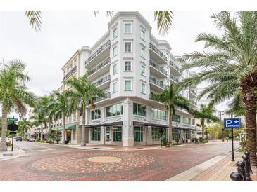 Elegant exterior showcases architectural details, with lush palm trees enhancing its appeal at 1500 State St # 305, Sarasota, FL 34236