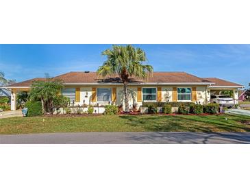 Charming single-story home featuring a well-maintained lawn and a mature palm tree at 303 Grayston Pl # C133, Sun City Center, FL 33573