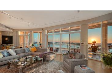 Elegant living room featuring floor-to-ceiling windows with stunning water views and a plush seating arrangement at 340 S Palm Ave # 152, Sarasota, FL 34236