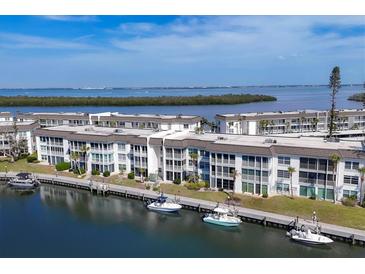 Scenic aerial view of waterfront condos with boat docks, lush landscaping, and calming water views at 4390 Exeter Dr # I305, Longboat Key, FL 34228