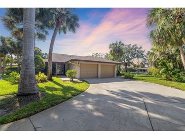Charming single-story home featuring a two-car garage, lush landscaping, and a long driveway at 6650 Schooner Bay Cir # 6650, Sarasota, FL 34231