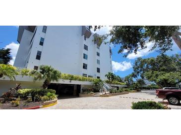 Condo building featuring manicured landscaping, covered parking, and convenient access to nearby amenities at 1200 E Peppertree Ln # 305, Sarasota, FL 34242