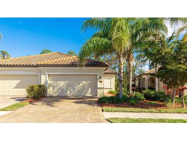 Charming villa with paver driveway, neutral paint, and a well manicured front yard, showcasing Florida living at 20170 Benissimo Dr, Venice, FL 34293