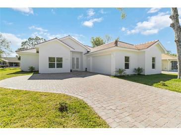 Beautiful single-story home with a red tile roof, brick driveway, and meticulously maintained landscaping at 23117 Hammond Ave, Port Charlotte, FL 33954