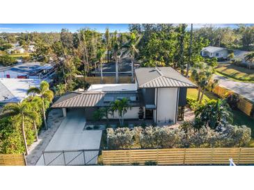 Striking modern home with a metal roof, gated entrance, and manicured landscaping at 3026 Mayflower St, Sarasota, FL 34231