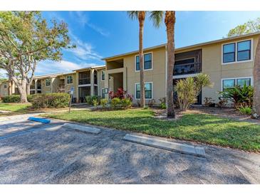 Inviting two-story condo building featuring well-maintained landscaping, palm trees and ample parking at 4061 Crockers Lake Blvd # 2611, Sarasota, FL 34238