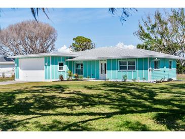 Charming turquoise home with a well-manicured lawn on a sunny day at 400 Dona Dr, Nokomis, FL 34275