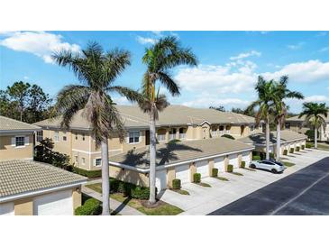Charming condo complex with tile roof and attached garages, surrounded by mature palm trees and greenery at 6326 Grand Oak Cir # 101, Bradenton, FL 34203