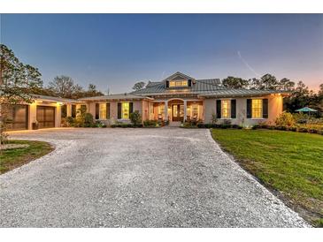 Charming single-story home featuring a circular driveway and lush landscaping at 19610 66Th E Ave, Bradenton, FL 34211