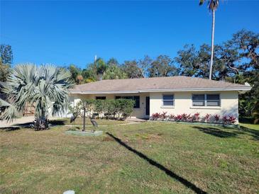 Charming single-story home featuring a well-maintained lawn, mature trees, and tasteful landscaping at 2611 Ashton Rd, Sarasota, FL 34231