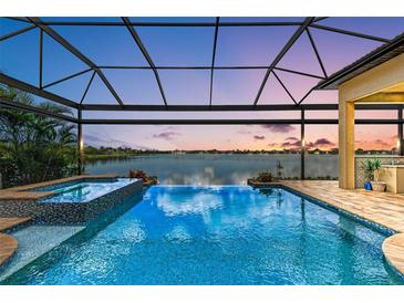 Stunning screened pool boasts a tranquil lake view, an attached spa, and seamless zero-edge design at 272 Maraviya Blvd, Nokomis, FL 34275