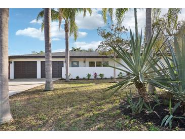 Charming single-story home featuring a two-car garage and a well-maintained front yard with mature palms at 2746 Tangelo Dr, Sarasota, FL 34239