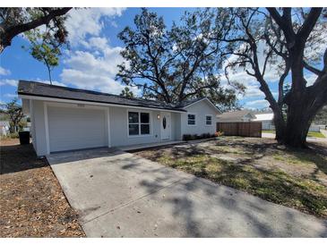 Charming one-story home with a well-maintained lawn, inviting entrance and large shade trees at 3325 Woodmont Dr, Sarasota, FL 34232