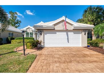 Home exterior with a two-car garage, brick driveway and mature landscaping at 538 Fallbrook Dr, Venice, FL 34292