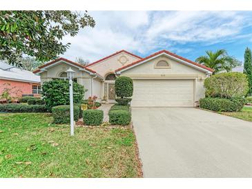 Charming one-story home with a red tile roof, well-manicured lawn, and a two-car garage at 5513 83Rd E Ter, Sarasota, FL 34243