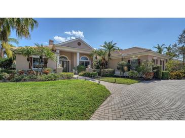 Charming one-story home with manicured lawn, elegant walkway, and lush tropical landscaping at 7303 Westminster Ct, University Park, FL 34201