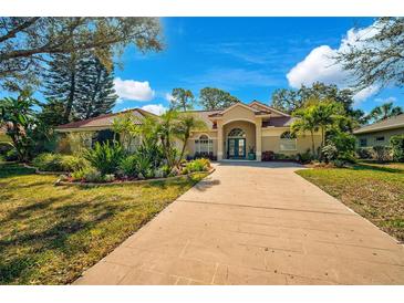 Beautiful single Gathering home featuring a red tile roof, mature landscaping, and a long drive in a sunny location at 2081 Timucua Trl, Nokomis, FL 34275