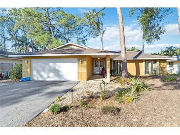 Charming single-story home featuring a spacious two-car garage and a welcoming entrance, nestled amidst lush trees at 2118 Wells Av, Sarasota, FL 34232