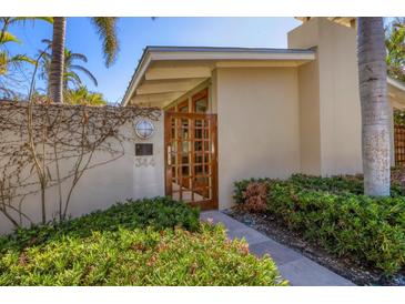 Charming home entrance with a wooden gate, lush landscaping, and clear address number at 344 Monroe Dr, Sarasota, FL 34236