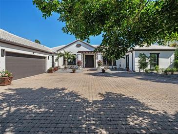 Charming home featuring a brick paver driveway, manicured landscaping, and a welcoming front entrance at 355 W Royal Flamingo Dr, Sarasota, FL 34236