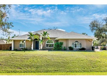 Attractive single-Gathering home with a well-maintained lawn, mature landscaping, and a paved driveway at 4540 Maverick St, North Port, FL 34288