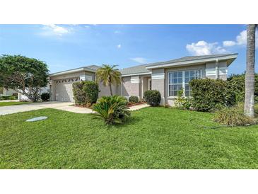 Charming home featuring lush green lawn, palm trees, and a two-car garage at 4937 Thames Ln, Sarasota, FL 34238