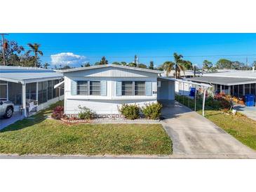 Charming single-story home with tidy landscaping, a long driveway, and a covered parking area at 511 50Th Avenue W Dr, Bradenton, FL 34207