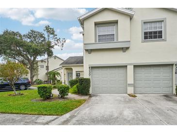 Two-story townhome featuring a two-car garage, neutral stucco exterior, and manicured lawn with shrubbery at 6330 Green Oak Cir # D, Bradenton, FL 34203