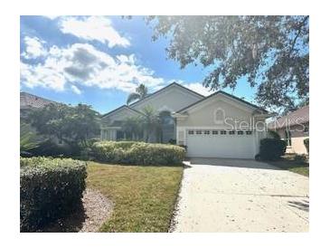 Charming one story home featuring a well-manicured lawn, a two car garage, and mature landscaping at 6504 Virginia Xing, University Park, FL 34201