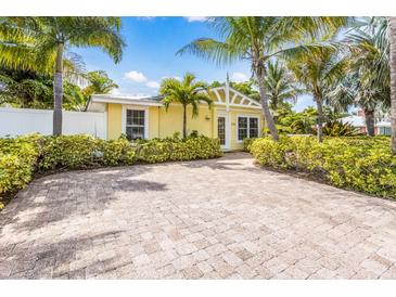 Charming yellow home with lush landscaping, brick drive, and sunny curb appeal at 6606 Holmes Blvd # 3, Holmes Beach, FL 34217