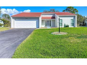 Inviting home with a well-maintained lawn, a paved driveway, and a classic white exterior at 7225 Las Casas Dr, Sarasota, FL 34243