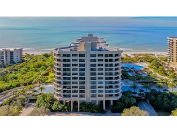 Luxury high-rise condo building with beautiful ocean views, lush landscaping, and a swimming pool at 1211 Gulf Of Mexico Dr # 701, Longboat Key, FL 34228