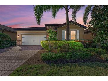 Charming home features a well-manicured lawn, stone accents, and a two-car garage in a tranquil neighborhood at 167 Maraviya Blvd, Nokomis, FL 34275