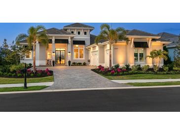 Stunning home featuring a paver driveway, manicured landscaping, and a welcoming three-car garage at 17217 Verona Pl, Lakewood Ranch, FL 34202