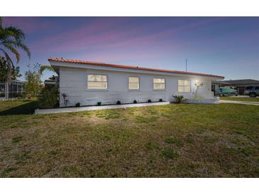 Charming single-story home featuring white brick and a red tile roof, set in a neatly manicured lawn at 4912 Beacon Rd, Palmetto, FL 34221