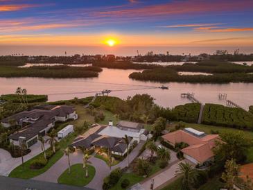 Breathtaking aerial view of waterfront home at sunset, showcasing lush landscaping and water access at 525 S Shore Dr, Osprey, FL 34229