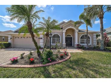 Beautiful home featuring a well-manicured lawn and mature palm trees, plus an attractive, arched entry at 10030 Reagan Dairy Trl, Bradenton, FL 34212