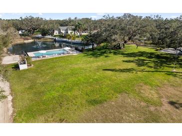 Expansive backyard featuring lush lawn, pool, and pond with fountain at 1228 Wagon Wheel Dr, Sarasota, FL 34240
