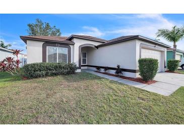 Charming single-story home with well-maintained front yard and attached garage, situated under a clear, sunny sky at 13227 Prestwick Creek Dr, Riverview, FL 33579