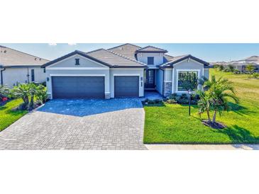 Beautiful home featuring a three-car garage and a well-manicured lawn with lush landscaping at 4968 Seafoam Trl, Bradenton, FL 34211