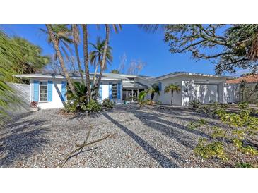 Charming home featuring well-kept landscaping, a large garage, and blue shutters at 710 Birdsong Ln, Sarasota, FL 34242