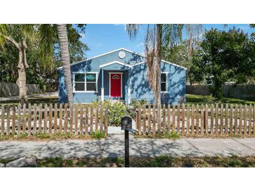 Charming home featuring blue siding, a vibrant red door, and a picket fence for a cozy curb appeal at 1367 21St St, Sarasota, FL 34234