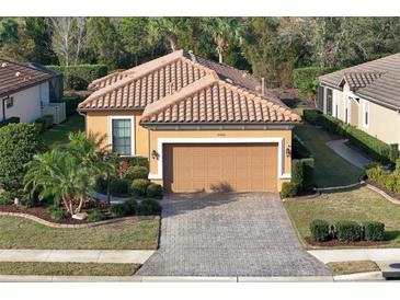 Charming single-story home with a tile roof, neatly landscaped yard, and a paver driveway leading to an attached garage at 5020 Savona Run, Bradenton, FL 34211