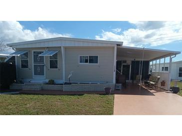 Charming single-story home featuring a covered porch, awning windows, and a well-maintained lawn at 1750 Palm Springs St, Sarasota, FL 34234