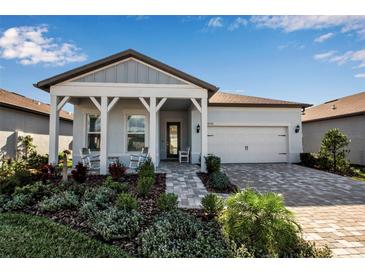 Charming single-story home with a covered porch, well-manicured landscaping, and a two-car garage at 8541 Coastal Palms Gln, Parrish, FL 34219