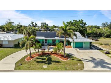 Charming single-story home with a circular driveway, well-maintained landscaping, and solar panels at 198 Salem Nw Ave, Port Charlotte, FL 33952